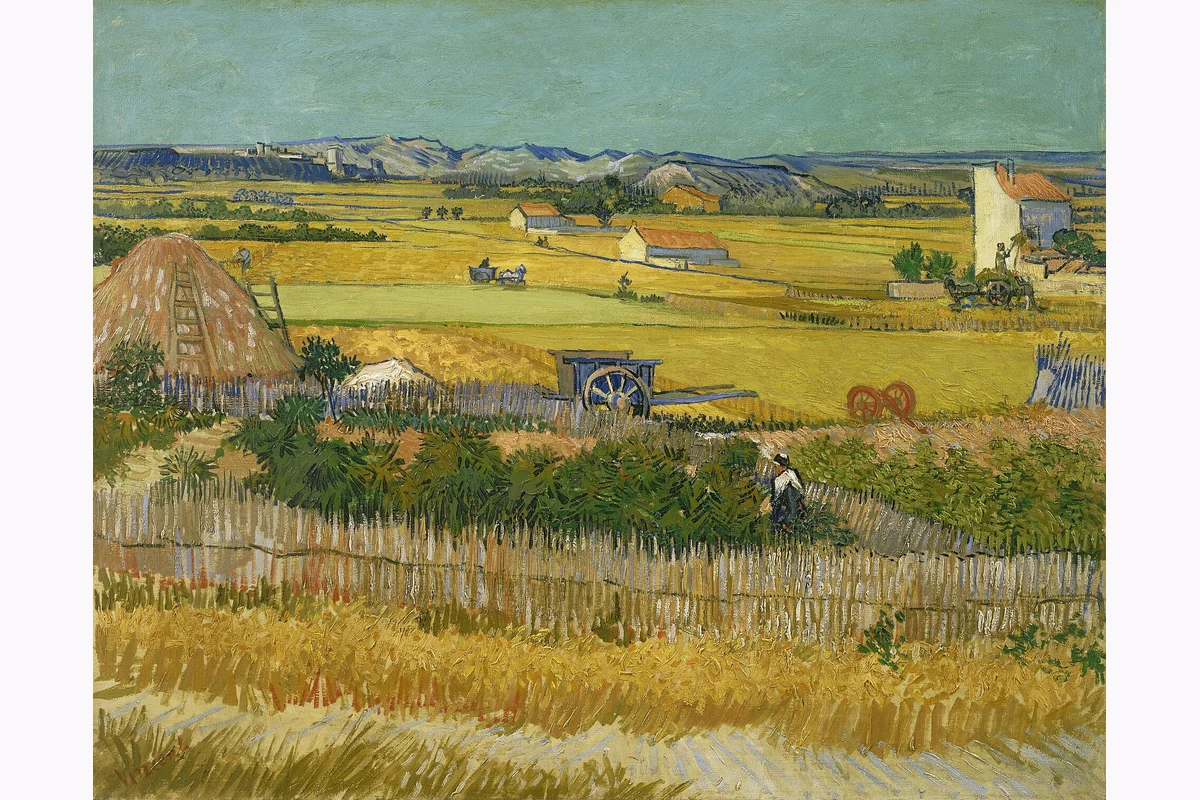 Campos de cosecha con carros y casas al fondo.