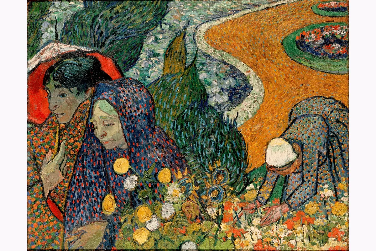 Dos mujeres entre flores y caminos de un jardín.